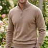 Man wearing Massoti Italian extrafine lambswool half-zip sweater in fawn, styled in a classic garden setting – premium Italian knitwear for gentlemen