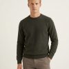 Man wearing Massoti Italian extrafine lambswool crew neck jumper in forest green, studio portrait – premium Italian knitwear for gentlemen