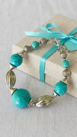 Aleyne Earth & Sky Bracelet turquoise beads stainless steel on fabric background