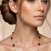 Woman wearing black onyx beaded station necklace 14K gold