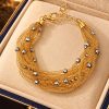 Portico bracelet, ten strands of Italian gold-finished silver mesh with rhodium spheres, in a jewellery box.